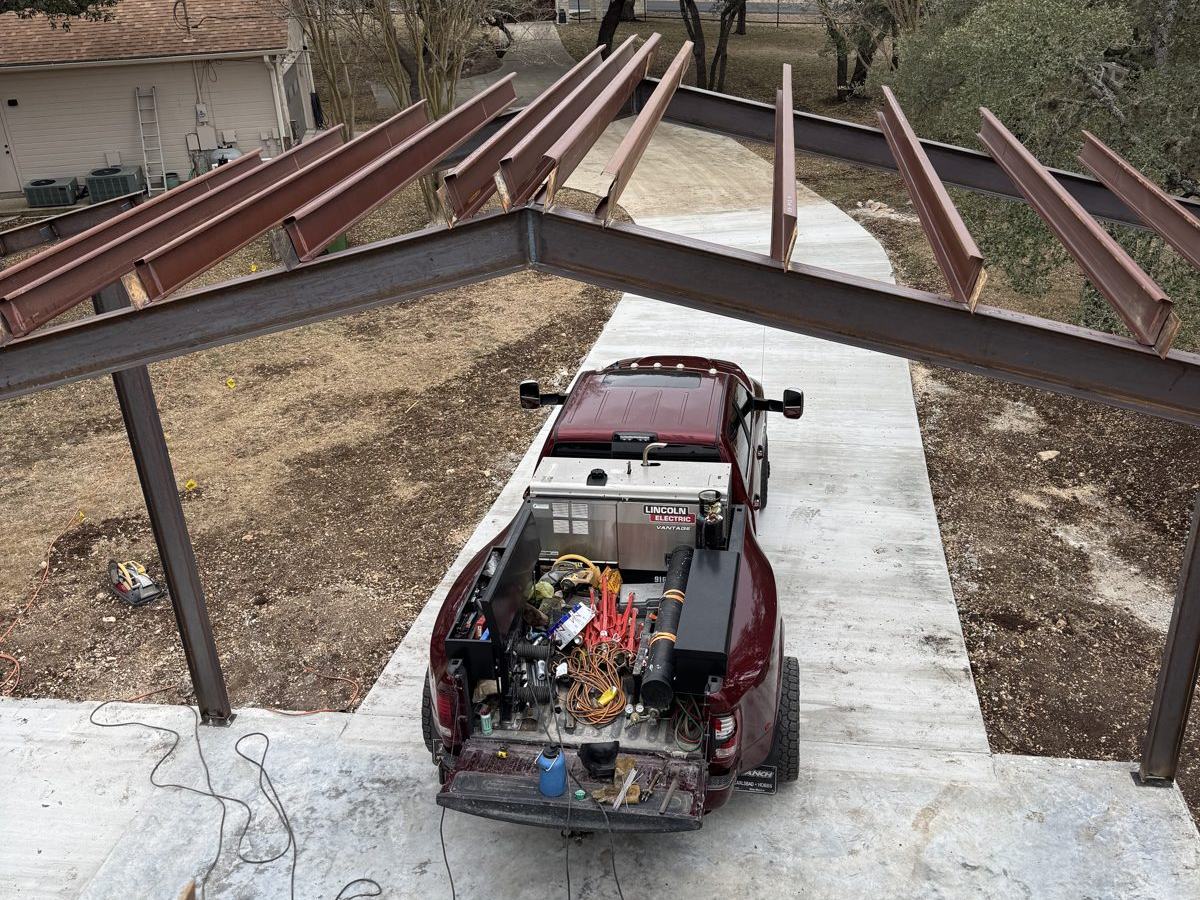Overhead view of a steel building frame with the welding truck below