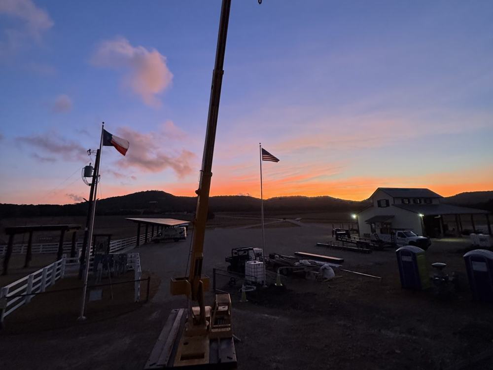 Crane boom against a dusk sky on a job site