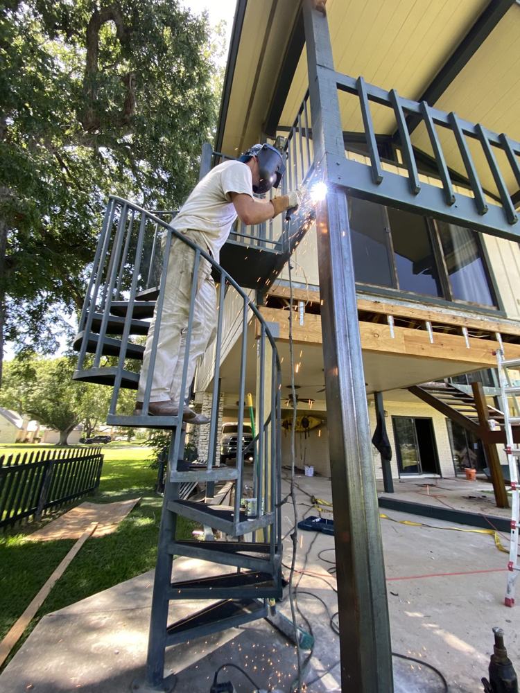Luke welding a custom steel exterior staircase