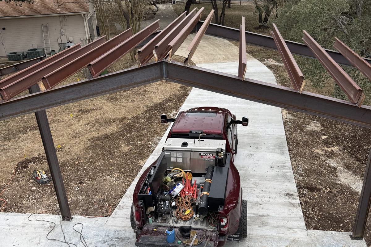 Overhead view of a steel building going up, welding truck below