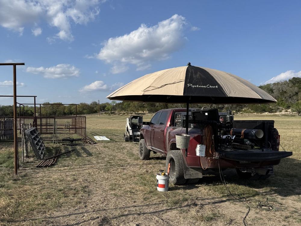 The welding truck set up under an awning on a ranch job